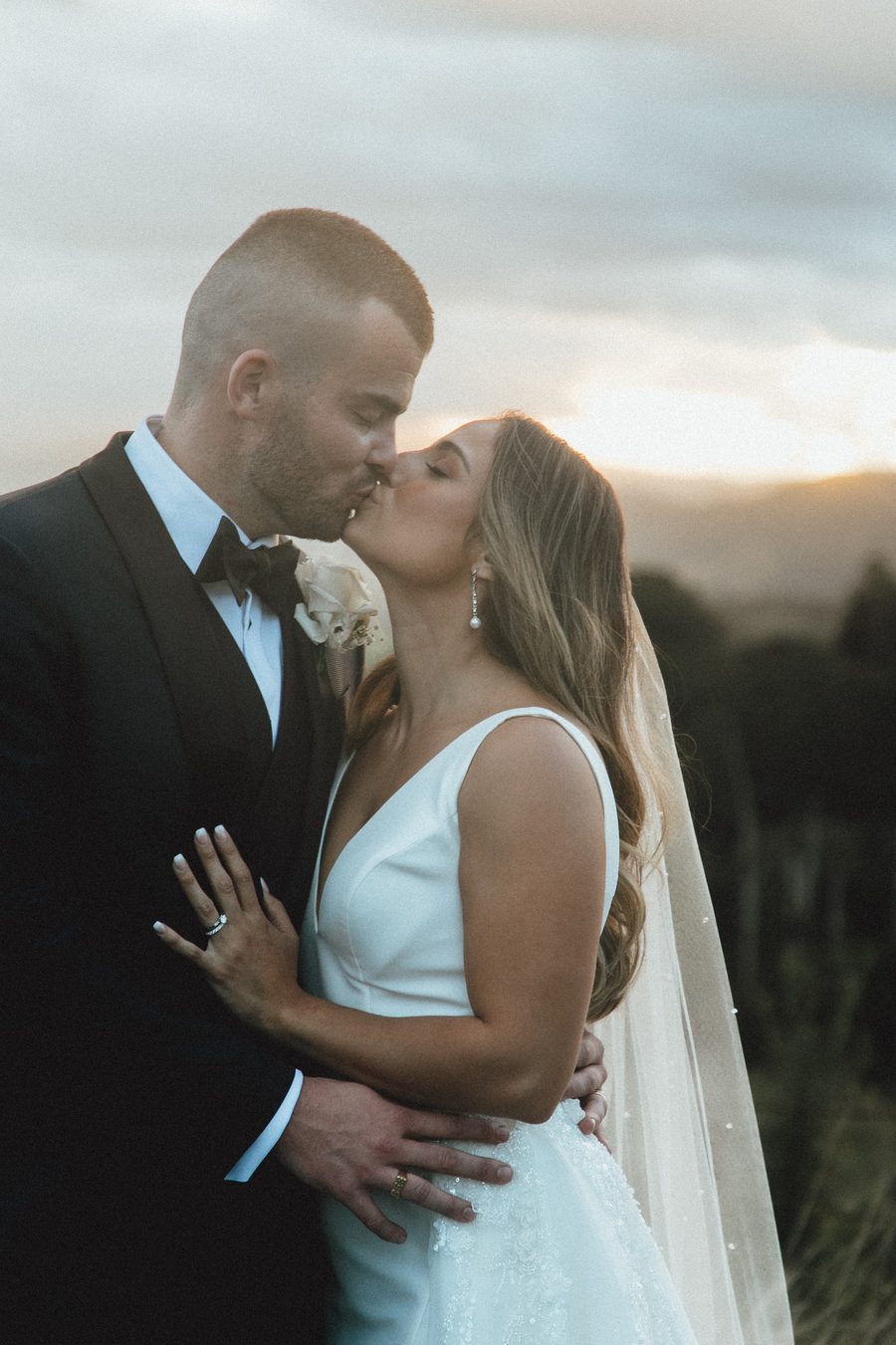 Bride and groom having an intimate moment at sunset