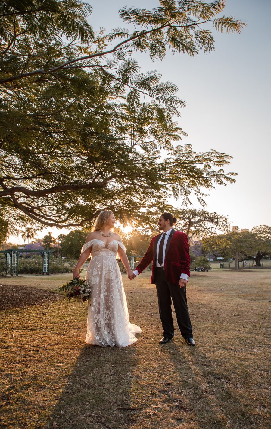 A couple holding hands and looking at one another in the sunset