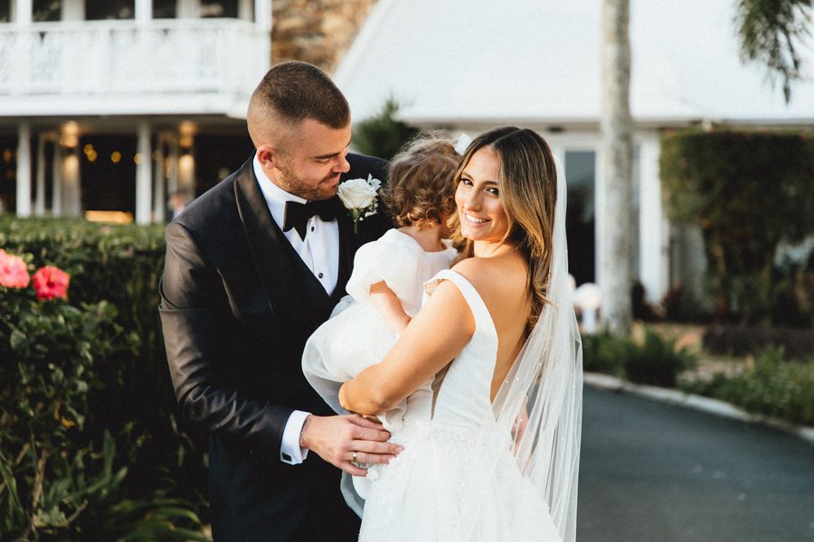 Bride and groom hugging their daughter at wedding